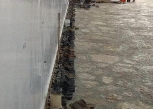 See that man on the left, in chequered shirt, bent over. 
 That’s him almost done arranging the many, many sandals and s…